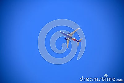 Colorful Southwestern airplane flying through very blue cloudless sky - view from below - room for copy Editorial Stock Photo