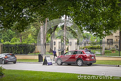 06-01-2019 Tulsa USA Valet parking on neighborhood street outside luxious fenced estate with many tall trees Editorial Stock Photo
