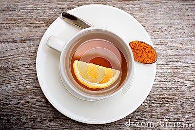 Tumeric tea with lemon slice on wood background. Stock Photo