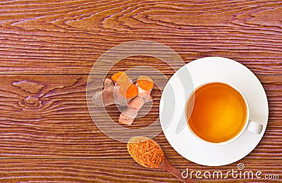 Cup of hot Turmeric tea isolated on wood table Stock Photo