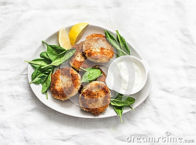 Tuna and potato patties served with spinach and greek yogurt on a light background, top view Stock Photo