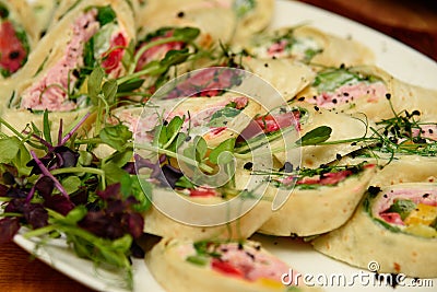 Tuna wrap sandwiches with spinach and vegetables on the plate. Stock Photo