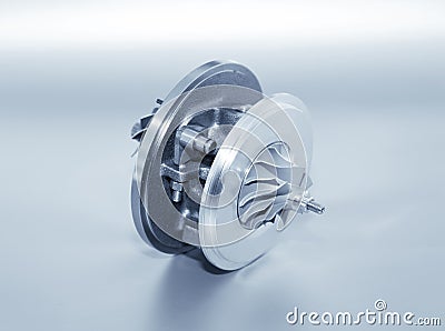 Turbocharger on metallic background. Car turbine - part of engine. Blue toned. Stock Photo