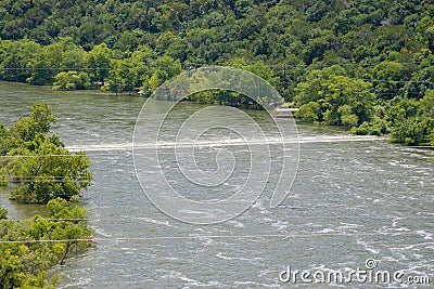 The turbulent line of water across the river is a submerged road Stock Photo