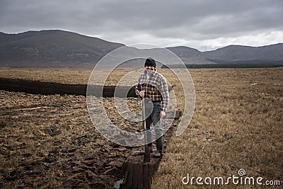 A turf cutter in the middle of the extensive peat bog Editorial Stock Photo