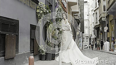 Turkey, Istanbul - July 27, 2022: Young fashionable luxury girl bride in elegant long wedding white dress in the narrow Editorial Stock Photo