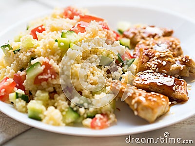 Turkey meat, fried, with teriyaki sauce and sesame seeds. A side dish of Couscous with vegetables. Stock Photo