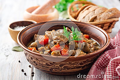 Turkey meat stew with mushrooms and vegetables in ceramic bowl on wooden table Stock Photo