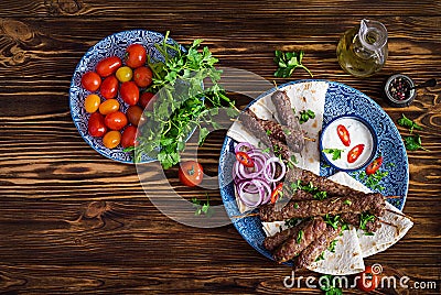 Kebab adana, chicken, lamb and beef on lavash bread with sauce. Stock Photo