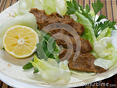 Turkish cigkofte and lemon on lettuce, lettuce, parsley, mint Stock Photo