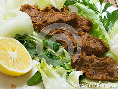 Turkish cigkofte and lemon on lettuce, lettuce, parsley, mint Stock Photo