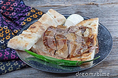 Turkish cuisine lamb ribs on pita bread. Tandoori style lamb chops and spiked pita served with green peppers and onions Stock Photo