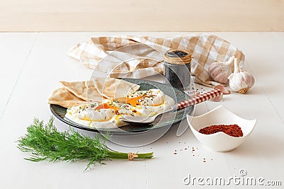 Turkish eggs Cilbir with lavash bread, dill and sesame seeds Stock Photo