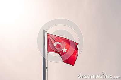 The Turkish flag flutters in the wind against the sky. Stock Photo