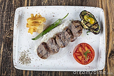 Turkish Food Meatball Kofte. Kofta with Tomatoes and Onion in Plate Portion. Grilled Kofte. Spicy meatballs Kebab or Kebap healthy Stock Photo