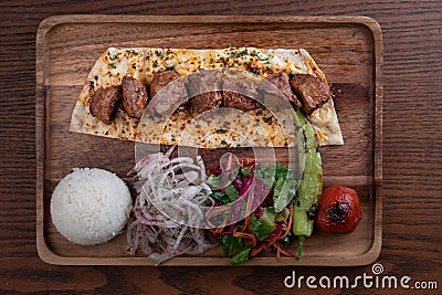 Turkish lamb sis kebab with rice and vegetables on wooden table Stock Photo