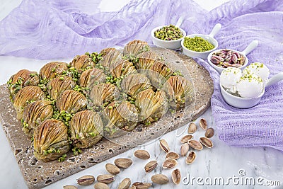 Turkish Midye Baklava Mussel Shape Baklava with green pistachio Powder and Butter Cream. Famous Turkish Gaziantep baklava Stock Photo