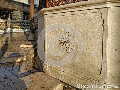 Turkish style architecture outside water faucet in stone with carvings on a sunny day Stock Photo