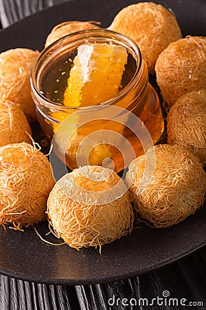Turkish sweets balls kadaif with fresh honey close-up. Vertical Stock Photo