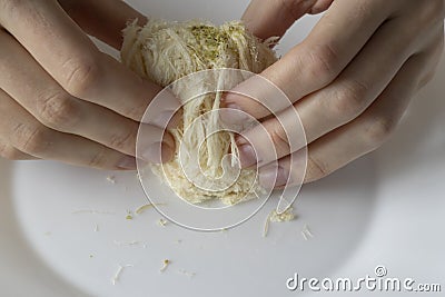 Turkish Traditional Dessert Pismaniye. A woman& x27;s hands tear the candy light halvah apart. Stock Photo