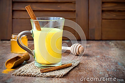 Turmeric golden milk latte with cinnamon sticks and honey. Detox liver fat burner, immune boosting, anti inflammatory drink Stock Photo