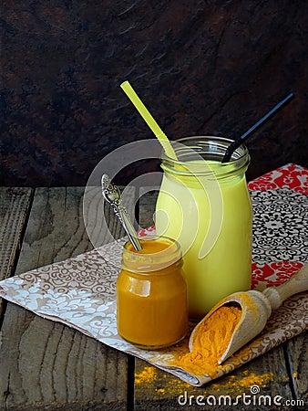 Turmeric powder, paste and latte on wooden background. Ayurvedic healthy golden drink with coconut milk and ghee for beauty and he Stock Photo