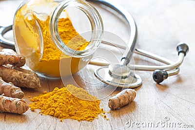 Turmeric powder and turmeric roots with stethoscope, natural medicine Stock Photo