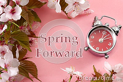 Turn clocks on hour ahead, star of daylight savings time change and reminder to spring forward concept with alarm clock on pink Stock Photo