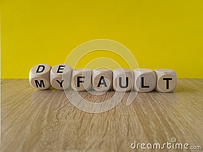 Turned dice and changes the expression my fault to default. Beautiful yellow background, wooden table. Copy space. Concept of Stock Photo