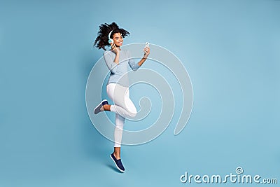 Turned full length body size photo of cheerful positive cute nice pretty girlfriend jumping up in white pants listening Stock Photo