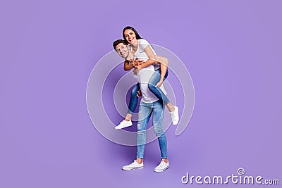 Turned full length body size photo of cute couple of two beloved people piggyback in white t-shirt smiling toothily with Stock Photo