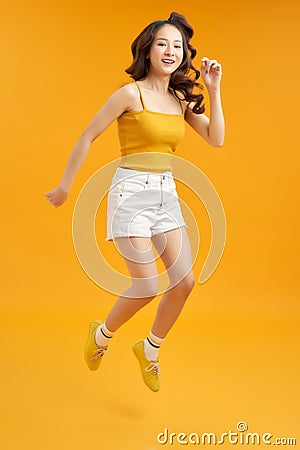 Turned full length body size photo of excited ecstatic beautiful attractive girl isolated over yellow background Stock Photo