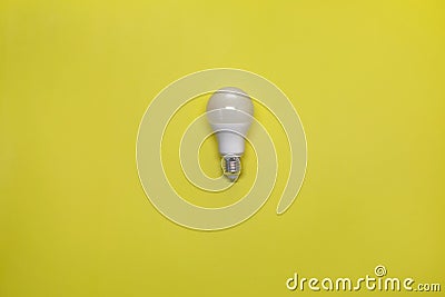 Turned off electric energy-saving lamp on a yellow background Stock Photo