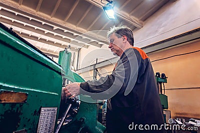 Turner for the machine, the machine operator controls the technological process of cutting and metal processing Stock Photo