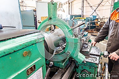 Turner worker manages the metalworking process of mechanical cutting on a lathe Stock Photo