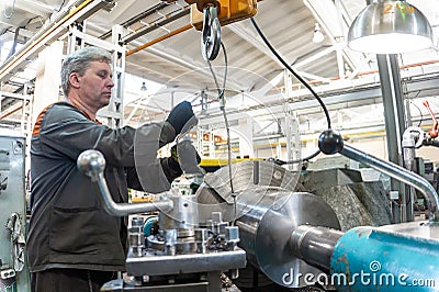 Turner worker manages the metalworking process of mechanical cutting on a lathe Stock Photo