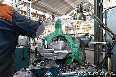 Turner worker manages the metalworking process of mechanical cutting on a lathe Stock Photo