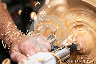 Turnery of a wooden bowl with spiral sawdust shavings Stock Photo