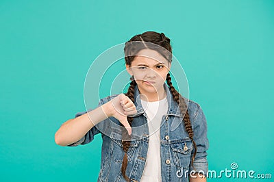 Turning thumbs down. Unhappy child give thumbs down blue background. Gesturing thumbs down. Thumbs down hand gesture Stock Photo