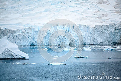 Shelf ice in Antarctica. Glacier wall with caves and small icebergs, Paradise Bay, Antarctica Stock Photo