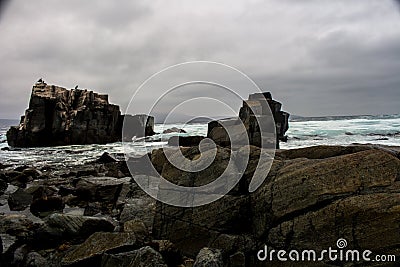 Turquoise waters and dark stones in winter Stock Photo