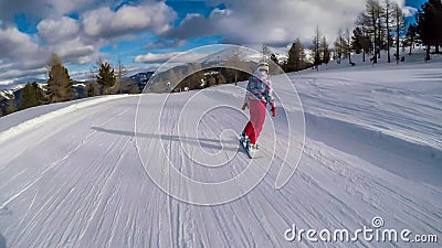 Turrach - A girl going down a snowy slope on a snowboard Stock Photo