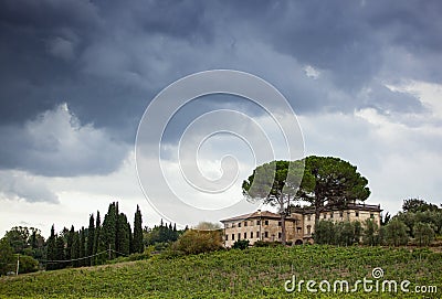 Tuscan hillside panorama with cloudy sky and typical local habit Stock Photo