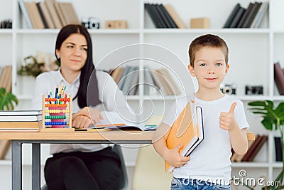 Tutor deals with the preschooler with a laptop, a real home interior, the concept of childhood and learning Stock Photo
