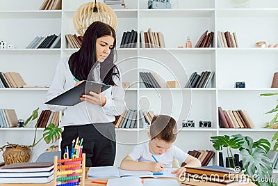 Tutor deals with the preschooler with a laptop, a real home interior, the concept of childhood and learning Stock Photo