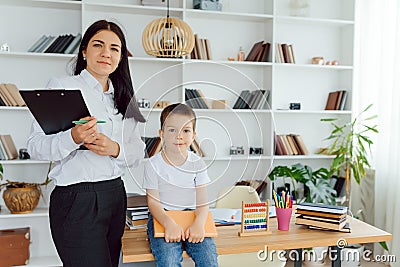 Tutor deals with the preschooler with a laptop, a real home interior, the concept of childhood and learning Stock Photo