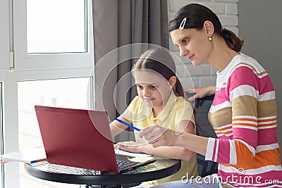 A tutor helps a girl learn online through the Internet Stock Photo