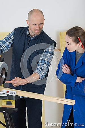 Tutor showing circular saw to student Stock Photo