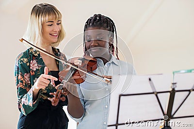 Tutor Teaching High School Student To Play Violin In Music Lesson Stock Photo