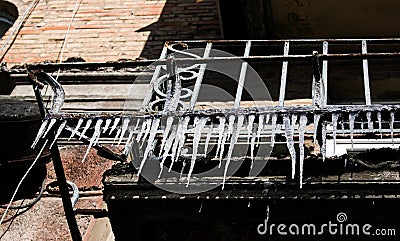 The TV antenna is covered with ice and icicles on the wall. Stock Photo